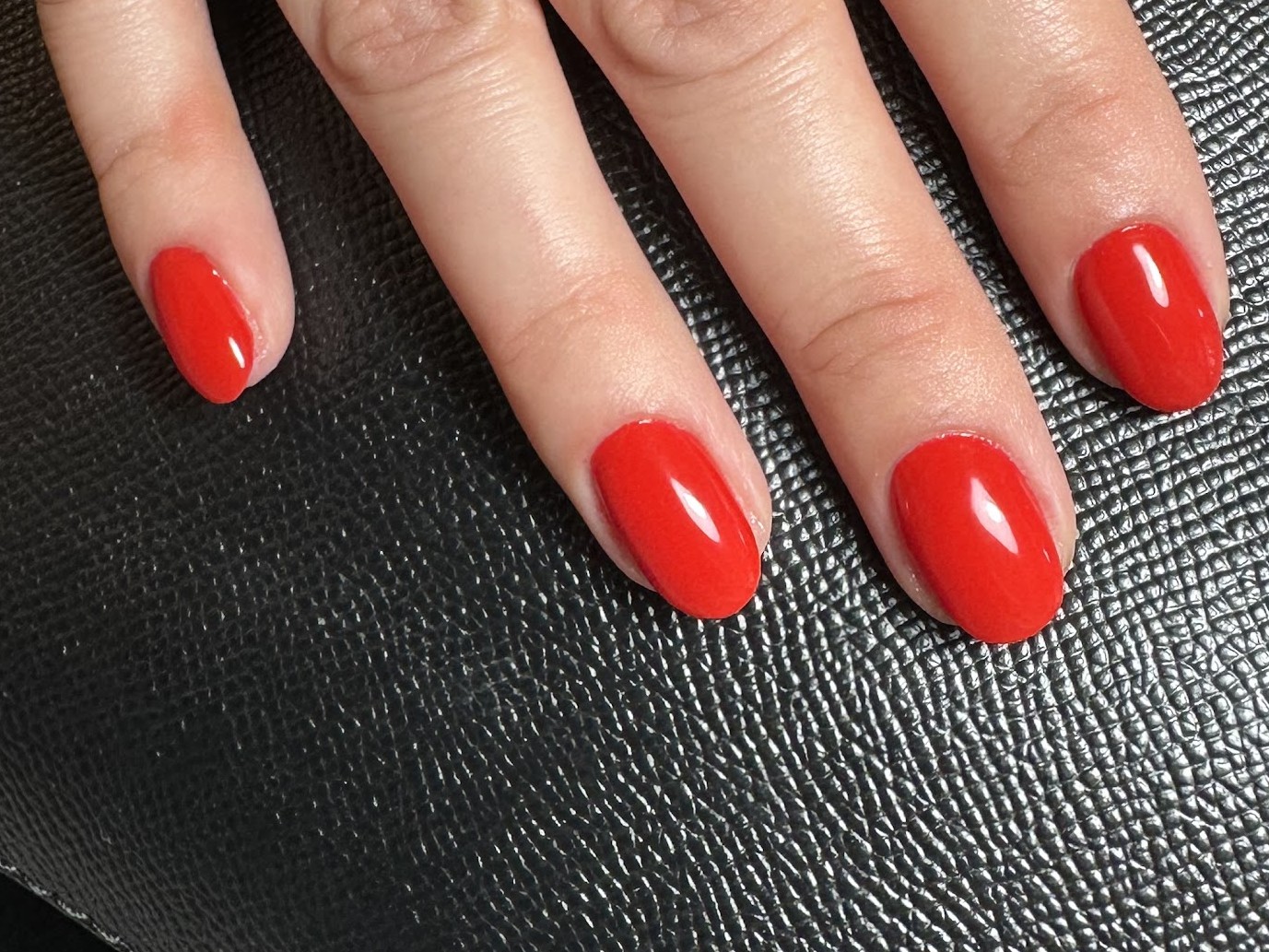 Rode nagels op een zwarte tas, foto van Anouk Jansen
